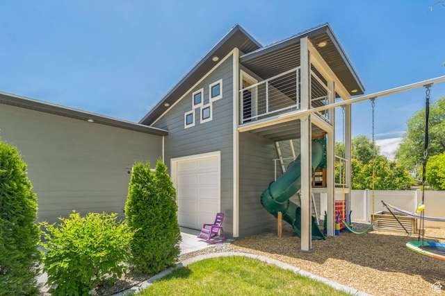 1186 W Marinwood Ave, Murray, UT 84123 - rear view of house with a playground, a garage, and a balcony