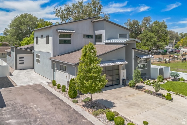 1186 W Marinwood Ave, Murray, UT 84123 - contemporary house with driveway, stucco siding, roof with shingles, metal roof, and a garage