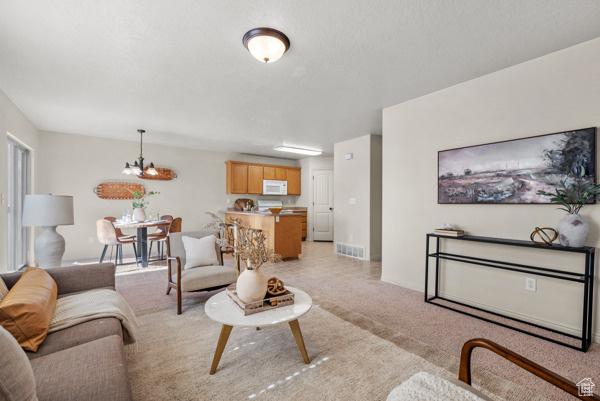 8064 N Clearwater Rd, Eagle Mountain, UT 84005 - living room with a chandelier and light colored carpet