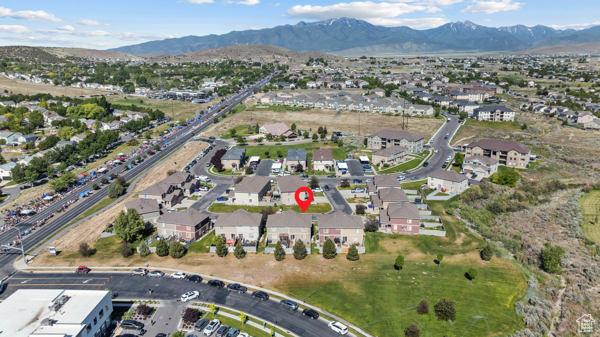 8064 N Clearwater Rd, Eagle Mountain, UT 84005 - aerial view of property and surrounding area with a mountain backdrop and nearby suburban area