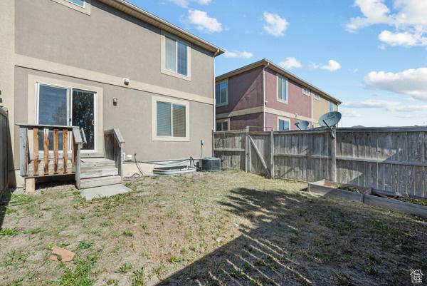 8064 N Clearwater Rd, Eagle Mountain, UT 84005 - back of property with stucco siding, a fenced backyard, and a deck