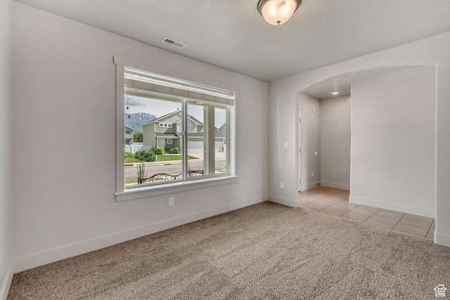 182 W Braeburn Ln, Santaquin, UT 84655 - unfurnished room featuring arched walkways, light carpet, baseboards, and light tile patterned flooring