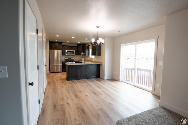 182 W Braeburn Ln, Santaquin, UT 84655 - kitchen featuring stainless steel appliances, a chandelier, dark brown cabinetry, a peninsula, and light wood-type flooring