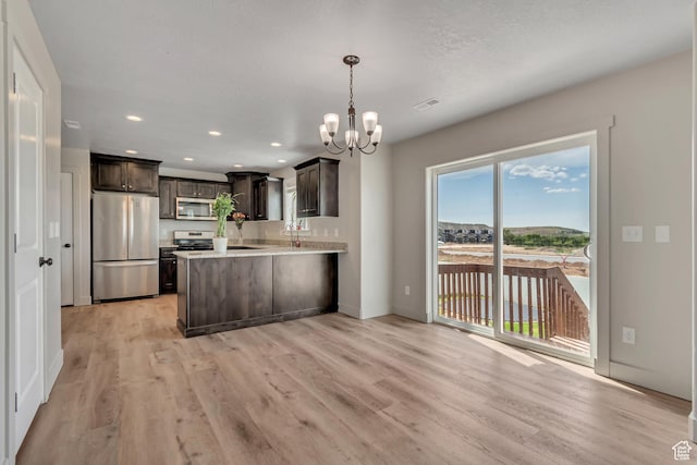 182 W Braeburn Ln, Santaquin, UT 84655 - kitchen with stainless steel appliances, a chandelier, light wood finished floors, dark brown cabinetry, and recessed lighting