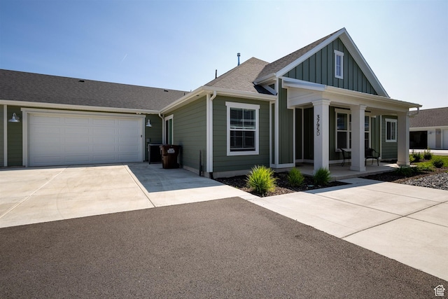 3795 S 4250 W Unit 446D, West Haven, UT 84401 - view of front of property with a porch, board and batten siding, driveway, a shingled roof, and an attached garage