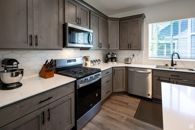 3795 S 4250 W Unit 446D, West Haven, UT 84401 - kitchen featuring appliances with stainless steel finishes, wood finished floors, a sink, and backsplash