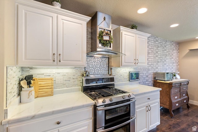 2127 Rio Grande Dr, Spanish Fork, UT 84660 - kitchen with range with two ovens, wall chimney range hood, white cabinetry, decorative backsplash, and recessed lighting