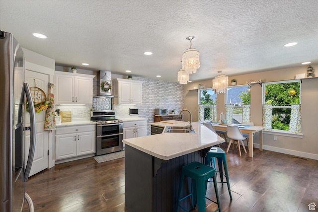 2127 Rio Grande Dr, Spanish Fork, UT 84660 - kitchen featuring stainless steel appliances, wall chimney range hood, a sink, a chandelier, and light countertops