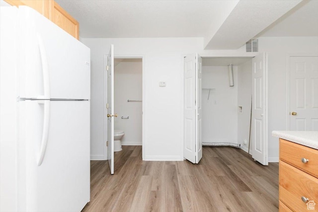356 S 400 W, Logan, UT 84321 - kitchen with freestanding refrigerator, light wood-style floors, light countertops, baseboards, and light brown cabinets