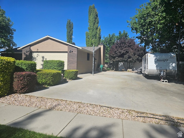 5235 S Spring Clover Dr W, Salt Lake City, UT 84123 - view of side of home featuring brick siding, an attached garage, and a chimney