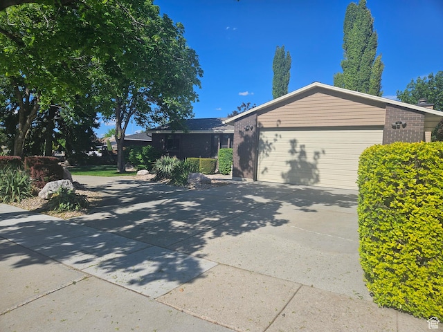 5235 S Spring Clover Dr W, Salt Lake City, UT 84123 - view of front of house with brick siding, an attached garage, and concrete driveway
