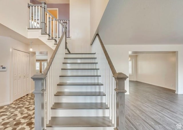 1231 E Tierney Cir, Sandy, UT 84094 - stairway featuring baseboards, a towering ceiling, and wood finished floors