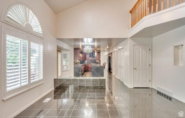 1231 E Tierney Cir, Sandy, UT 84094 - foyer with granite floors, a high ceiling, a chandelier, baseboards, and healthy amount of natural light