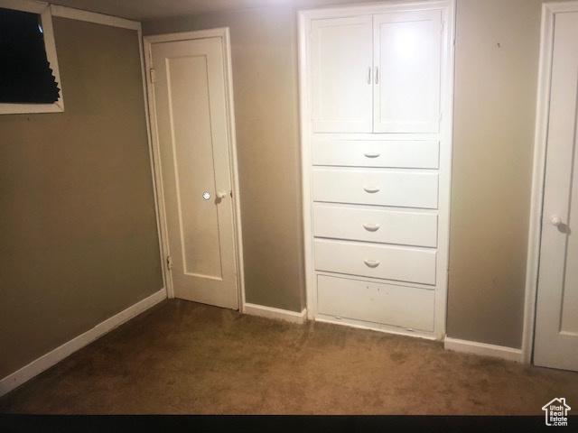 2726 S Cyprus Ln, Magna, UT 84044 - unfurnished bedroom with baseboards and dark colored carpet