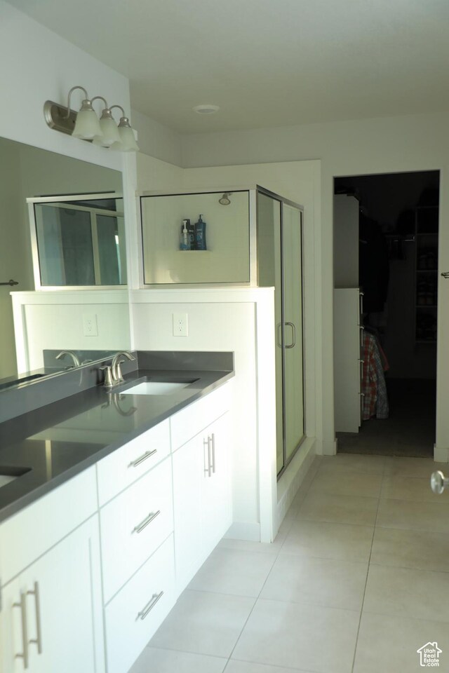 7315 N Stone Wall Cir, Eagle Mountain, UT 84005 - bathroom with tile patterned floors, double vanity, a stall shower, and a spacious closet