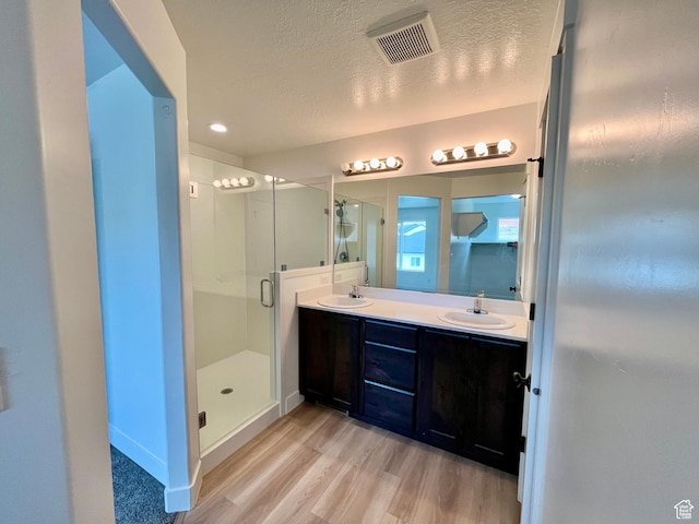 1937 S Freestone Blvd, Santaquin, UT 84655 - full bathroom featuring wood finished floors, double vanity, a shower stall, a textured ceiling, and baseboards