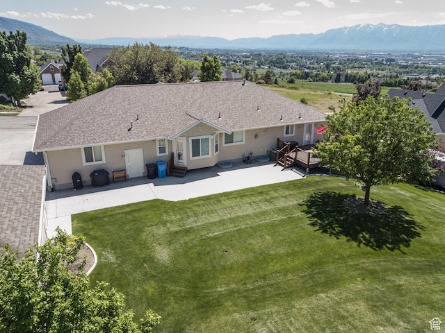 1655 E 3250 N, North Logan, UT 84341 - rear view of house with stucco siding, a lawn, a deck with mountain view, and a shingled roof