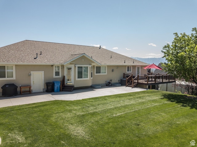 1655 E 3250 N, North Logan, UT 84341 - rear view of house featuring a patio, a wooden deck, roof with shingles, a lawn, and stucco siding