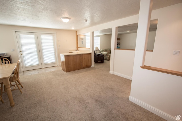 1655 E 3250 N, North Logan, UT 84341 - kitchen featuring light carpet, a textured ceiling, brown cabinetry, healthy amount of natural light, and light countertops