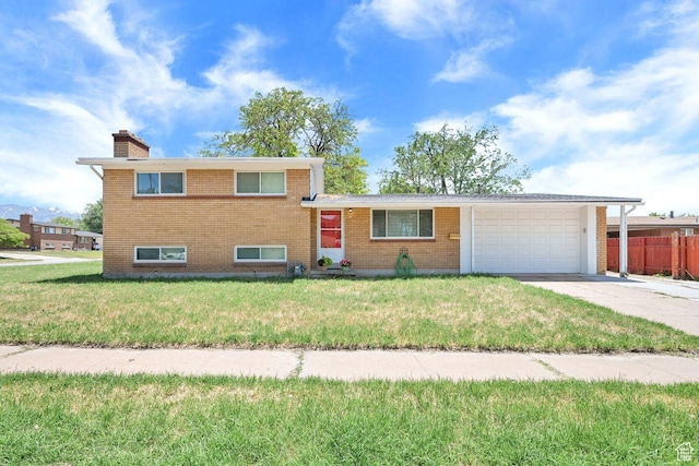 3 E Vine Cir N, Clearfield, UT 84015 - split level home featuring an attached garage, driveway, a chimney, and brick siding