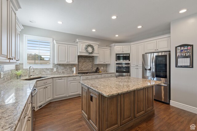 117 S 200 E, Kaysville, UT 84037 - kitchen with stainless steel appliances, a sink, a center island, backsplash, and white cabinets