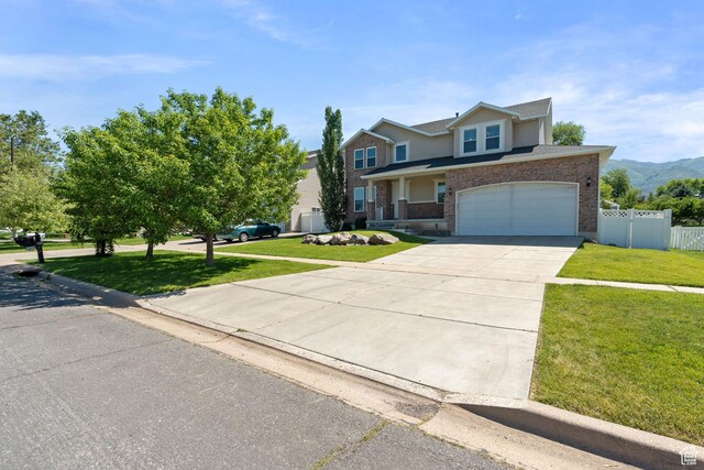 117 S 200 E, Kaysville, UT 84037 - traditional-style home with driveway, an attached garage, brick siding, and a mountain view