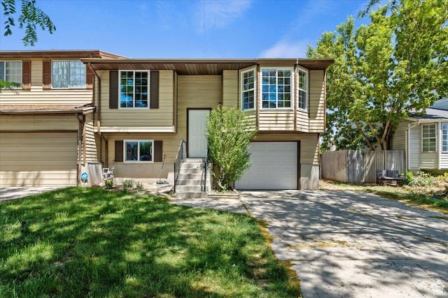 1622 W 8740 S, West Jordan, UT 84088 - raised ranch featuring a garage, concrete driveway, and entry steps