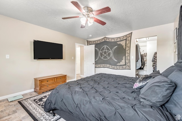 2316 E Claybourne Ave S, Millcreek, UT 84109 - bedroom featuring a textured ceiling, a walk in closet, baseboards, a ceiling fan, and a closet