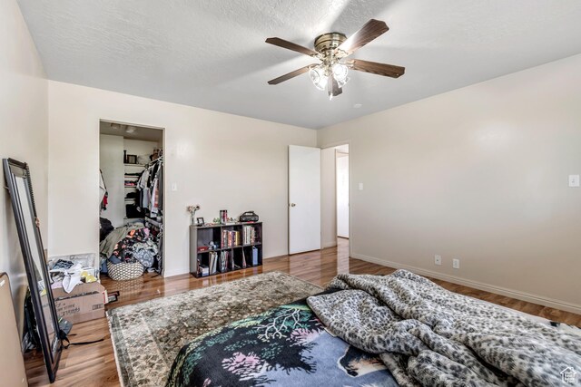 2316 E Claybourne Ave S, Millcreek, UT 84109 - bedroom with a walk in closet, wood finished floors, ceiling fan, and baseboards