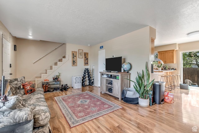 2316 E Claybourne Ave S, Millcreek, UT 84109 - living room with a textured ceiling, light wood-type flooring, and stairs