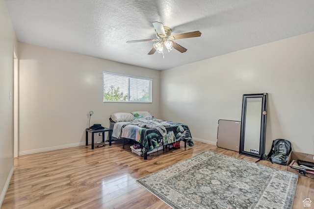 2316 E Claybourne Ave S, Millcreek, UT 84109 - bedroom featuring light wood finished floors, a textured ceiling, baseboards, and a ceiling fan