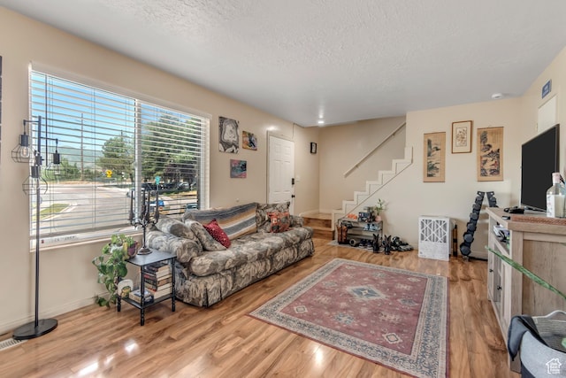 2316 E Claybourne Ave S, Millcreek, UT 84109 - living room with a textured ceiling, stairway, wood finished floors, and baseboards