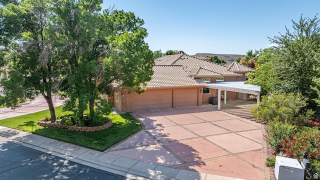 1287 W Bloomington Dr S Unit 7, Bloomington, UT 84790 - view of front of property featuring a tiled roof, an attached garage, concrete driveway, and stucco siding