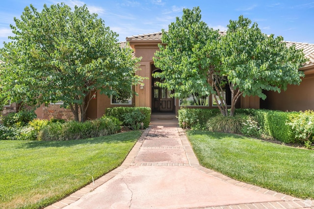 1287 W Bloomington Dr S Unit 7, Bloomington, UT 84790 - view of front of house with a front yard, stucco siding, and a tiled roof