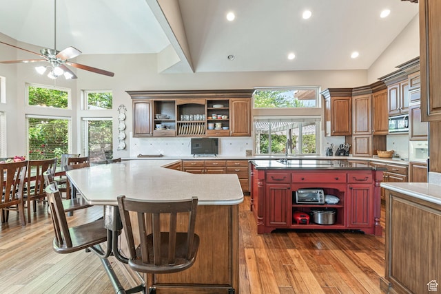 1287 W Bloomington Dr S Unit 7, Bloomington, UT 84790 - kitchen featuring open shelves, a center island, stainless steel microwave, a ceiling fan, and backsplash