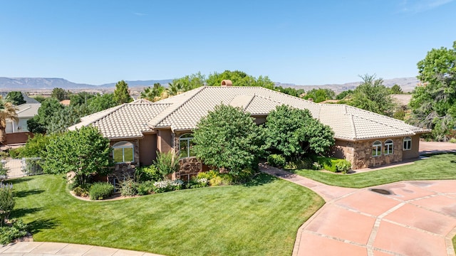 1287 W Bloomington Dr S Unit 7, Bloomington, UT 84790 - view of front of property with a tile roof, stone siding, a front lawn, and a mountain view