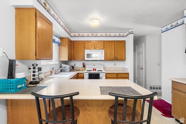 4924 W Barton Park Dr, West Jordan, UT 84081 - kitchen featuring white appliances, a sink, a peninsula, and light countertops