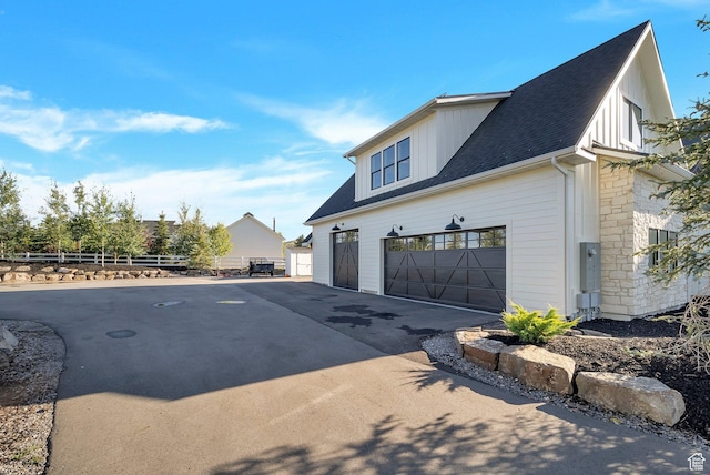 1474 E Rock View Ct, Kamas, UT 84036 - view of side of property featuring asphalt driveway, board and batten siding, a shingled roof, and an attached garage