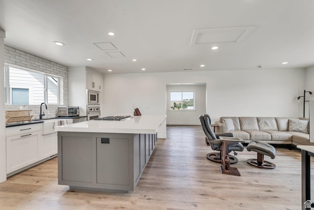 1474 E Rock View Ct, Kamas, UT 84036 - kitchen featuring appliances with stainless steel finishes, a kitchen island, open floor plan, white cabinets, and light wood-type flooring