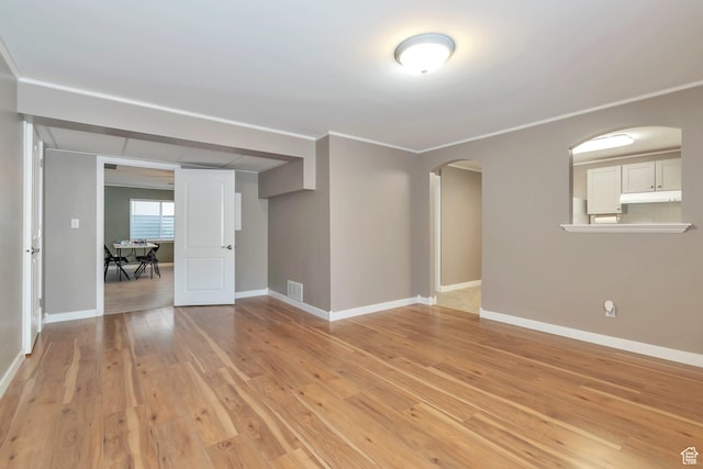 8567 S Cork Oak Dr, West Jordan, UT 84081 - spare room featuring arched walkways, light wood-type flooring, baseboards, and ornamental molding