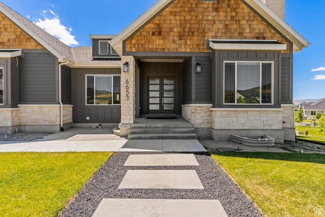 6653 W Dry Creek Ln, Highland, UT 84003 - view of front of house with stone siding, french doors, a front lawn, and board and batten siding