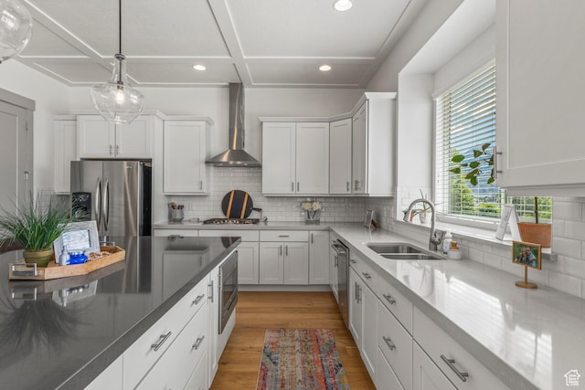 6653 W Dry Creek Ln, Highland, UT 84003 - kitchen featuring stainless steel appliances, wall chimney exhaust hood, a sink, recessed lighting, and light wood-type flooring