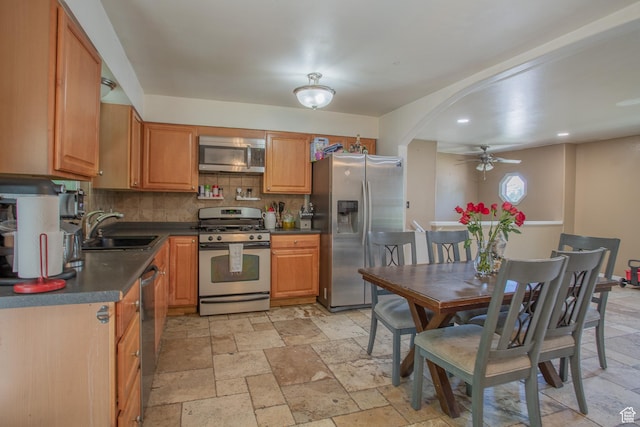 3746 S 7200 W, Magna, UT 84044 - kitchen with stainless steel appliances, a sink, ceiling fan, tasteful backsplash, and dark countertops