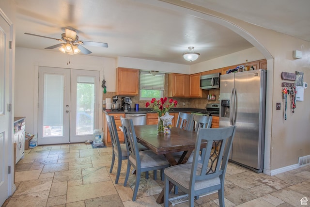3746 S 7200 W, Magna, UT 84044 - dining room with stone tile flooring, arched walkways, a ceiling fan, french doors, and baseboards
