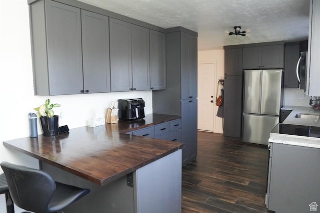 1204 Hyperion Way, Soda Springs, ID 83276 - kitchen with stainless steel appliances, a peninsula, dark wood finished floors, butcher block counters, and a sink