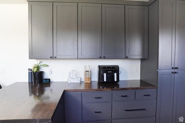 1204 Hyperion Way, Soda Springs, ID 83276 - kitchen with decorative backsplash, a peninsula, gray cabinets, and wood counters