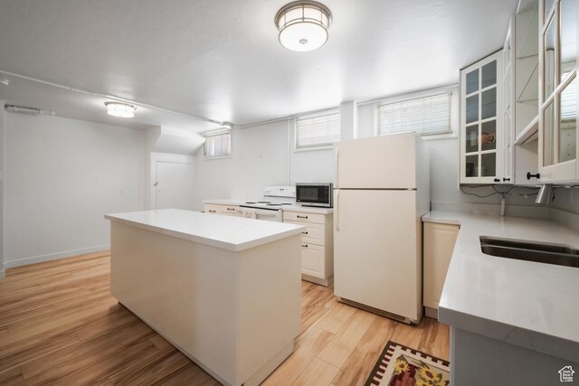 1377 E Wilson Ave, Salt Lake City, UT 84105 - kitchen with white appliances, a center island, light countertops, light wood-type flooring, and glass insert cabinets