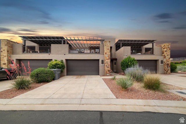 5048 N Escapes Dr, St George, UT 84770 - contemporary house featuring a balcony, stucco siding, concrete driveway, and an attached garage