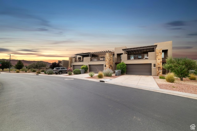 5048 N Escapes Dr, St George, UT 84770 - modern home with an attached garage, stucco siding, driveway, stone siding, and a balcony