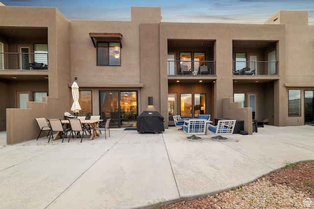 5048 N Escapes Dr, St George, UT 84770 - back of property featuring stucco siding, a balcony, a patio area, and outdoor dining space